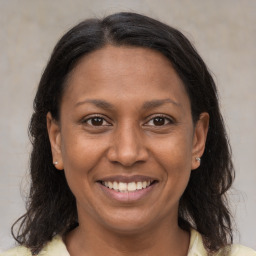 Joyful latino adult female with medium  brown hair and brown eyes