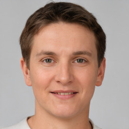 Joyful white young-adult male with short  brown hair and grey eyes