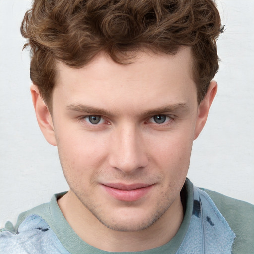 Joyful white young-adult male with short  brown hair and blue eyes