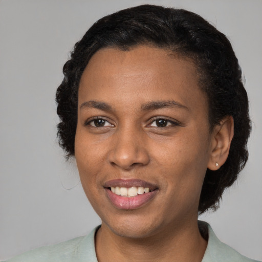 Joyful black young-adult female with short  black hair and brown eyes