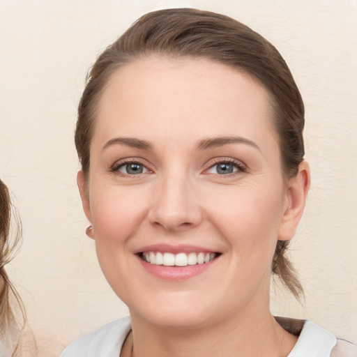 Joyful white young-adult female with medium  brown hair and blue eyes