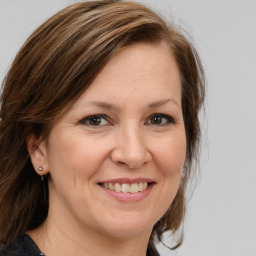 Joyful white adult female with medium  brown hair and grey eyes