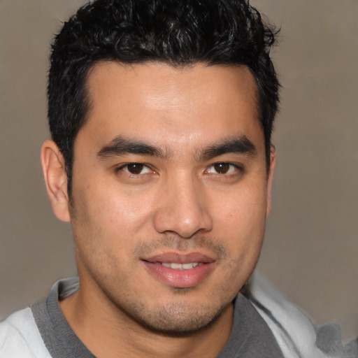 Joyful asian young-adult male with short  brown hair and brown eyes