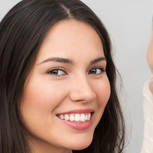 Joyful white young-adult female with long  brown hair and brown eyes