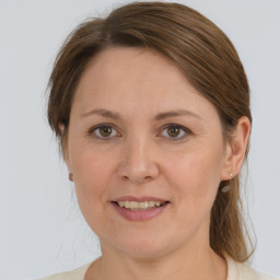 Joyful white adult female with medium  brown hair and grey eyes