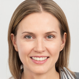 Joyful white young-adult female with medium  brown hair and grey eyes