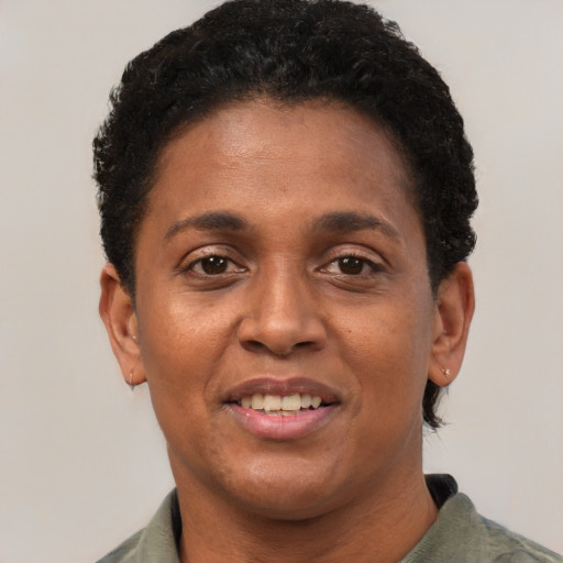 Joyful black adult female with short  black hair and brown eyes