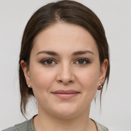 Joyful white young-adult female with medium  brown hair and grey eyes