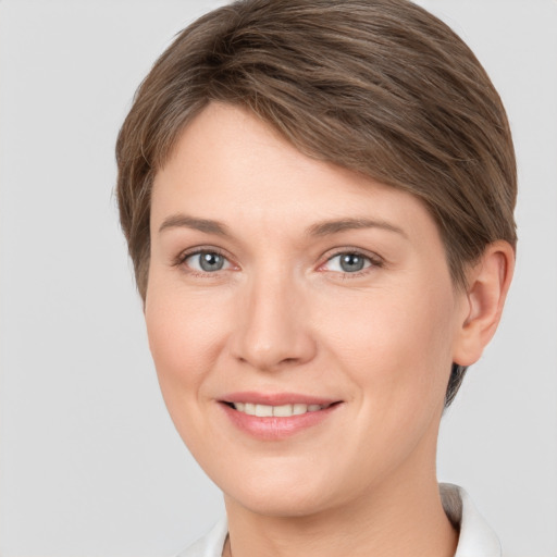 Joyful white young-adult female with short  brown hair and grey eyes