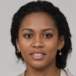 Joyful black young-adult female with long  brown hair and brown eyes