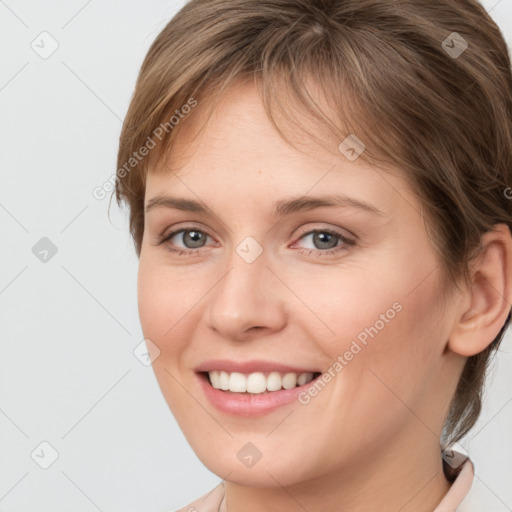 Joyful white young-adult female with medium  brown hair and grey eyes