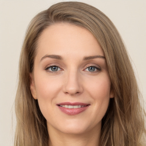 Joyful white young-adult female with long  brown hair and grey eyes