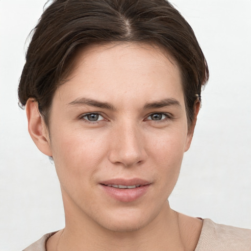 Joyful white young-adult female with short  brown hair and grey eyes