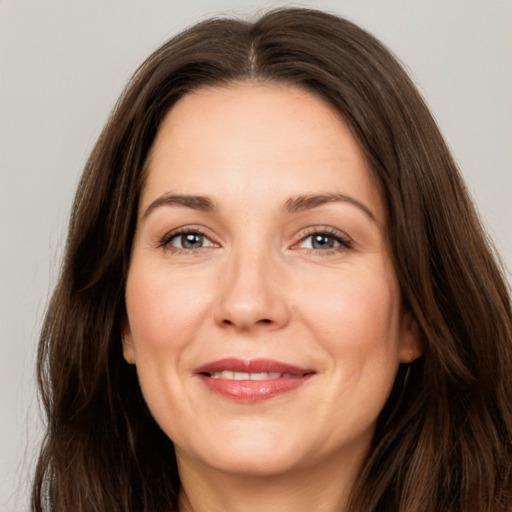 Joyful white adult female with long  brown hair and brown eyes