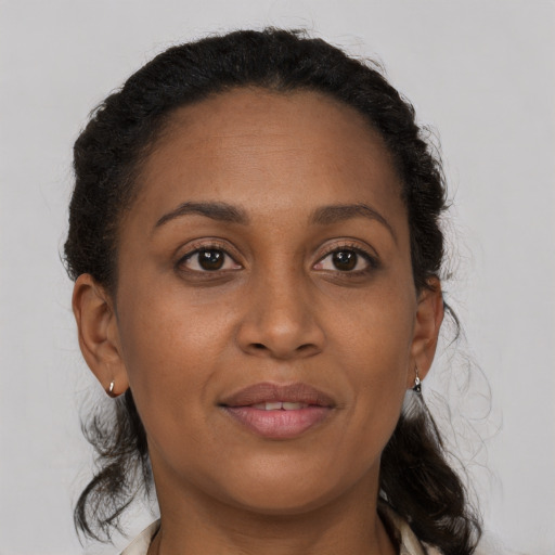 Joyful black adult female with medium  brown hair and brown eyes