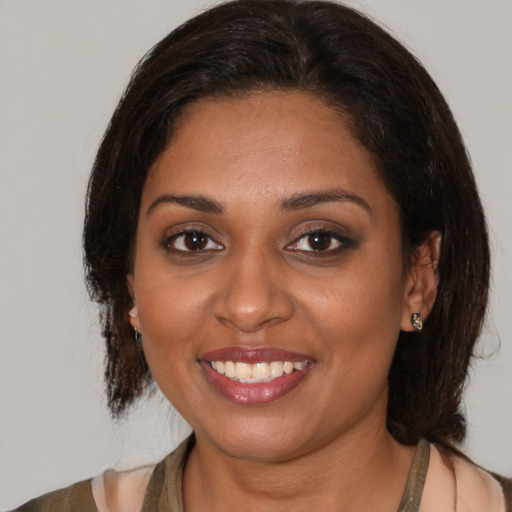 Joyful black young-adult female with medium  brown hair and brown eyes