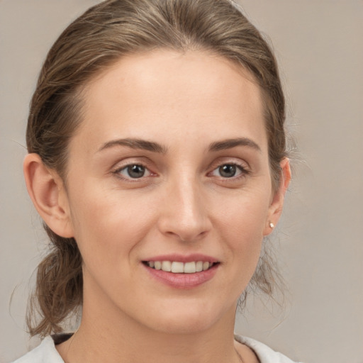 Joyful white young-adult female with medium  brown hair and grey eyes