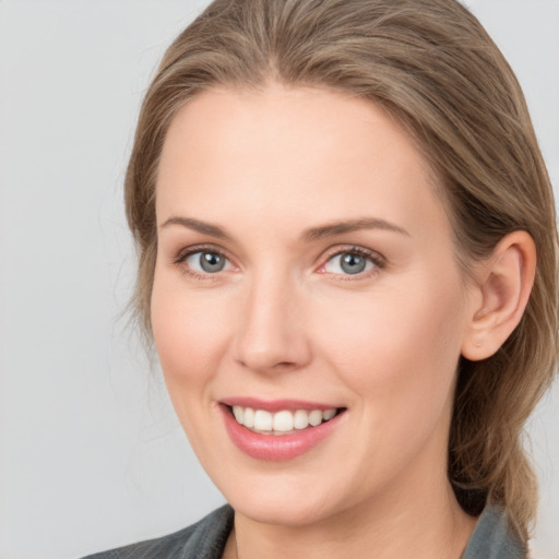 Joyful white young-adult female with medium  brown hair and grey eyes