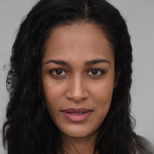 Joyful black young-adult female with long  brown hair and brown eyes