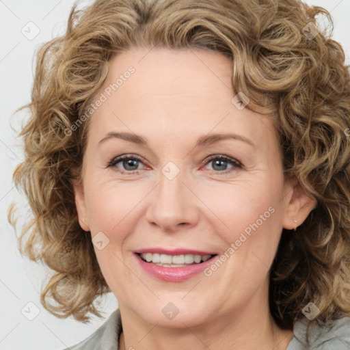 Joyful white adult female with medium  brown hair and blue eyes