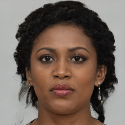 Joyful black young-adult female with medium  black hair and brown eyes