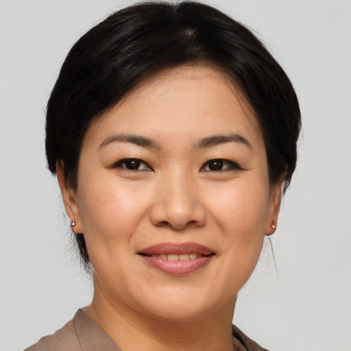 Joyful asian young-adult female with short  brown hair and brown eyes