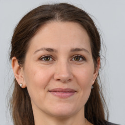 Joyful white adult female with long  brown hair and brown eyes