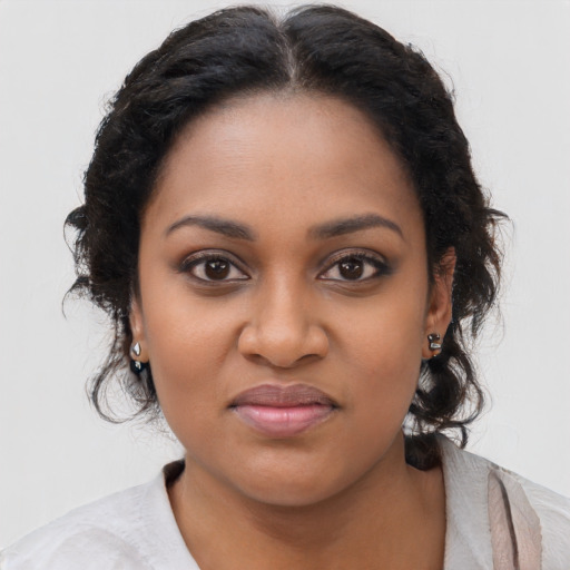 Joyful black young-adult female with long  brown hair and brown eyes