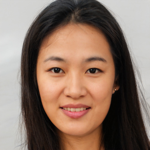 Joyful asian young-adult female with long  brown hair and brown eyes