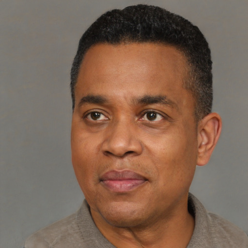 Joyful black adult male with short  black hair and brown eyes