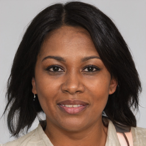 Joyful black adult female with medium  brown hair and brown eyes