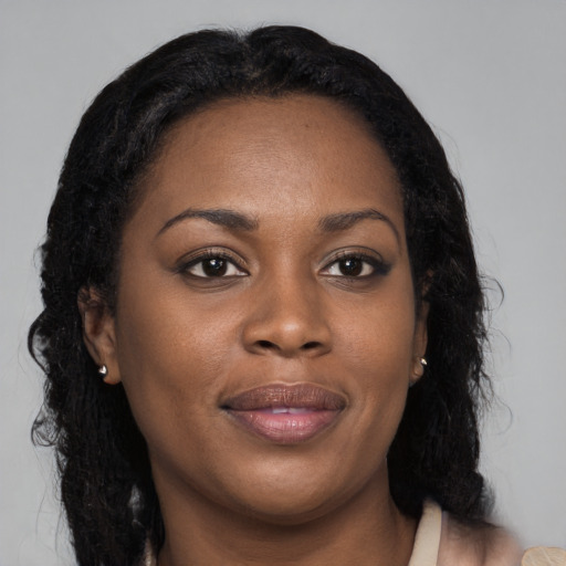 Joyful black young-adult female with long  brown hair and brown eyes