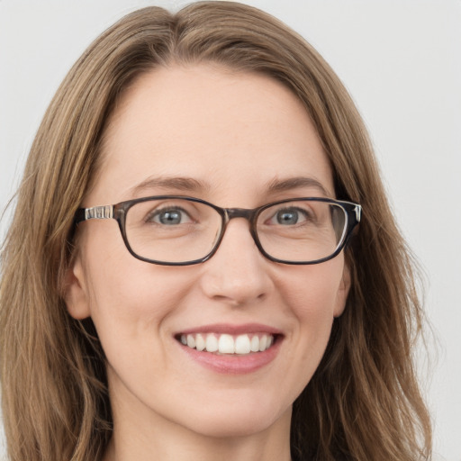 Joyful white young-adult female with long  brown hair and blue eyes