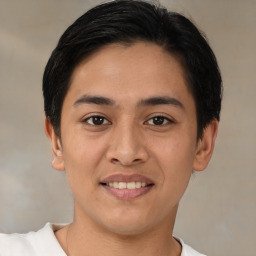 Joyful latino young-adult male with short  brown hair and brown eyes