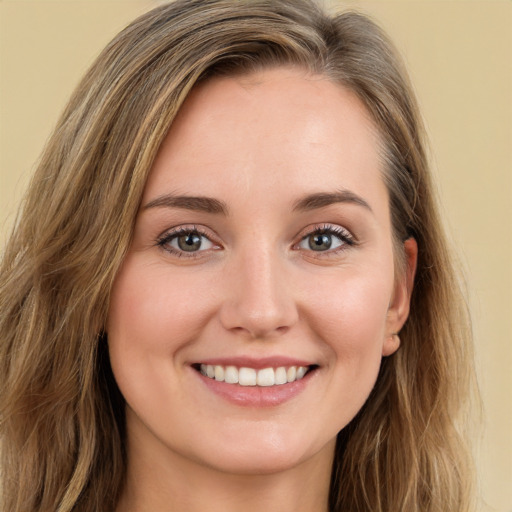 Joyful white young-adult female with long  brown hair and green eyes