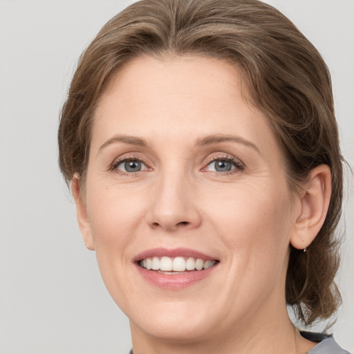 Joyful white adult female with medium  brown hair and grey eyes