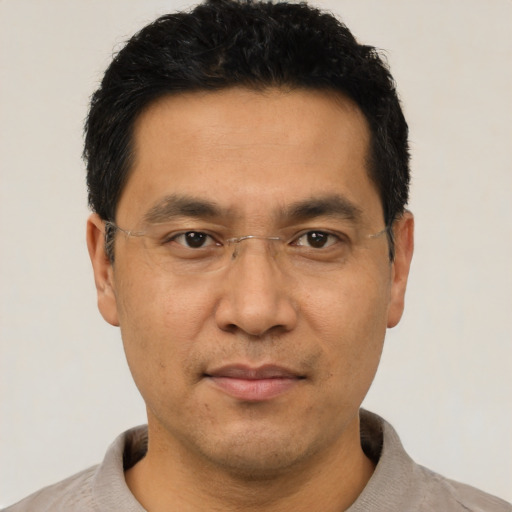 Joyful asian adult male with short  black hair and brown eyes