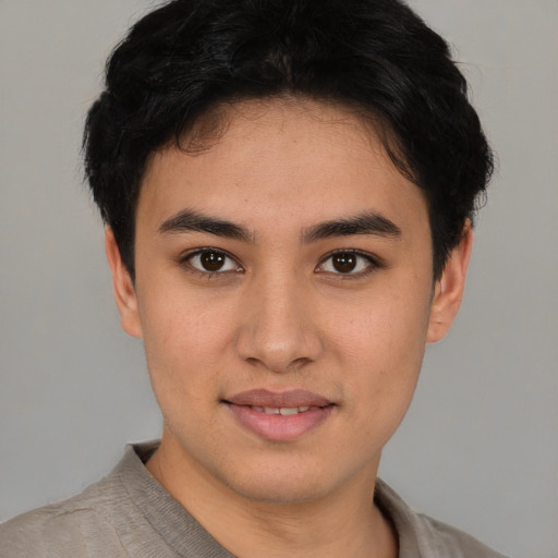 Joyful latino young-adult male with short  brown hair and brown eyes