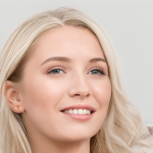 Joyful white young-adult female with long  blond hair and blue eyes