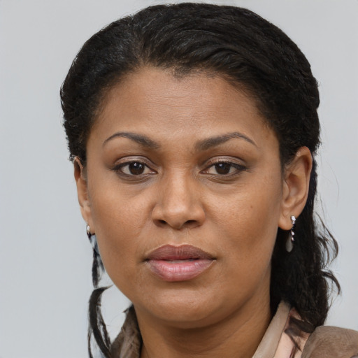 Joyful black adult female with long  brown hair and brown eyes