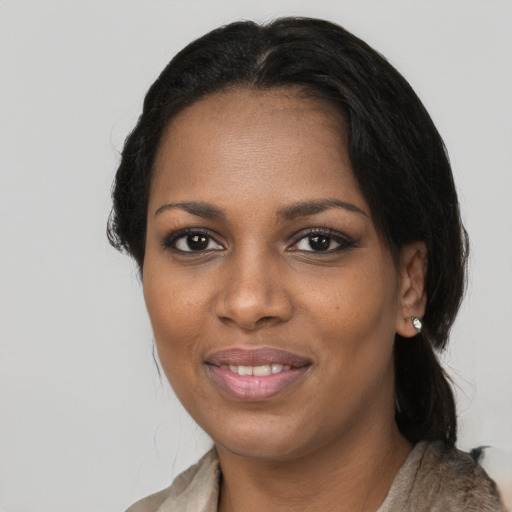 Joyful black young-adult female with long  black hair and brown eyes