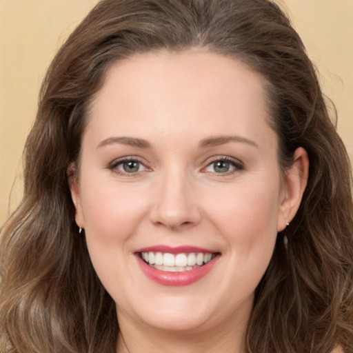 Joyful white young-adult female with long  brown hair and green eyes