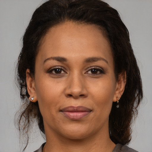 Joyful latino adult female with medium  brown hair and brown eyes
