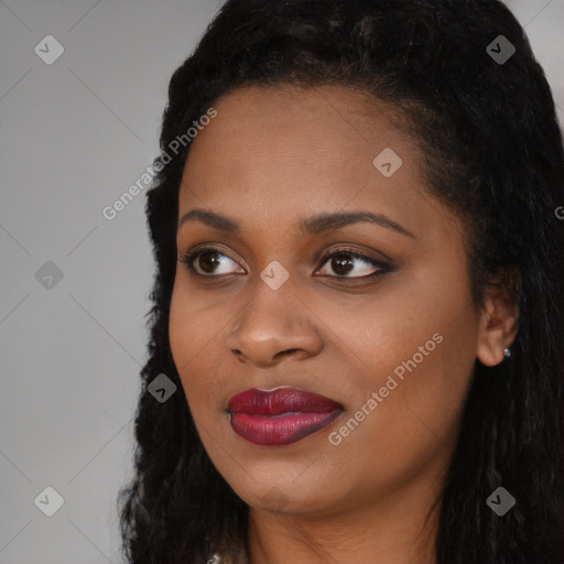 Joyful black young-adult female with long  black hair and brown eyes