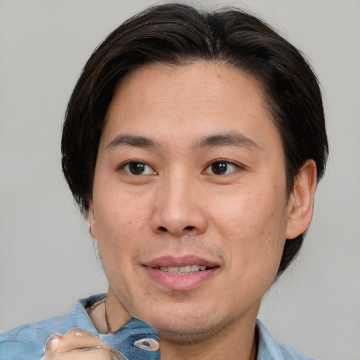 Joyful asian adult male with short  brown hair and brown eyes
