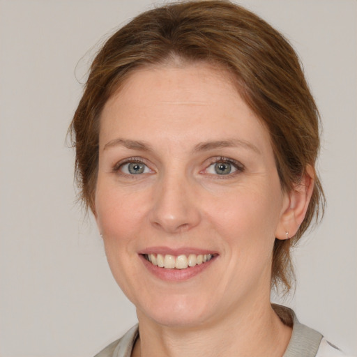 Joyful white adult female with medium  brown hair and grey eyes