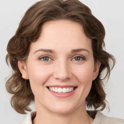 Joyful white young-adult female with medium  brown hair and green eyes