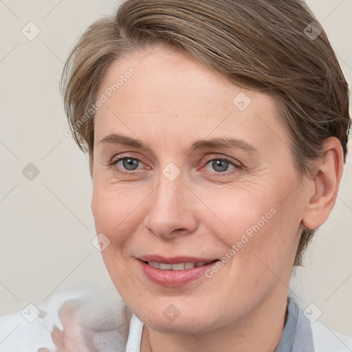 Joyful white adult female with medium  brown hair and blue eyes