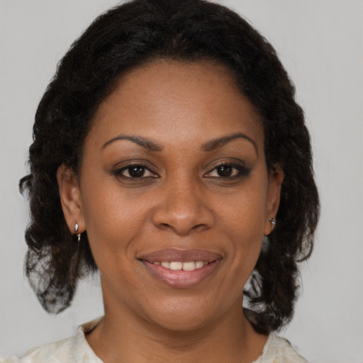 Joyful black adult female with medium  brown hair and brown eyes