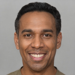 Joyful latino adult male with short  black hair and brown eyes